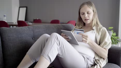 Fokussierte-Schwangere-Frau,-Die-Online-Mit-Einem-Tablet-Einkauft